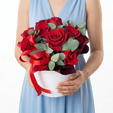 Красные розы в шляпной коробке и зелень